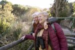 Viagem tranquila e acolhedora atrai público 60+ em Águas de Lindóia duas-amigas-seniores-desfrutando-de-uma-caminhada-juntos-na-natureza