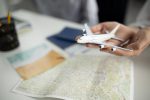 Confira os riscos de seguros de viagem "gratuitos" feche-as-maos-segurando-um-pequeno-aviao