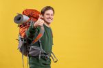 5 dicas para curtir uma viagem de mochilão e praticar seu inglês pelo mundo jovem-homem-com-mochila-se-preparando-para-uma-caminhada-sorrindo