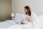 Como garantir a hospedagem perfeita? retrato-belas-jovens-mulheres-asiaticas-com-xicara-de-cafe-e-computador-portatil-na-cama