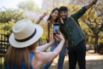 Descubra como se proteger dos 10 golpes mais comuns em turistas na Europa vista-lateral-mulher-tirando-fotos-de-amigos