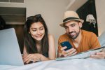 Entenda a renovação do acordo realizada pelo Ministério do Turismo e os descontos disponíveis para professores portrait-lovely-couple-organizing-their-trip-with-laptop-mobile-phone-hotel-room
