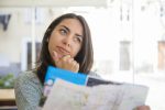 Destinos litorâneos dominam as viagens do feriado de Tiradentes dreamy-pretty-young-woman-using-paper-map-cafe
